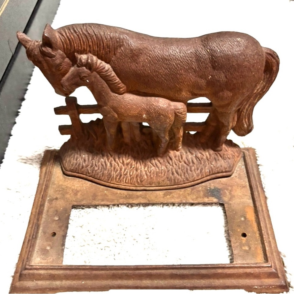 Vintage cast iron door stop featuring horse and foal.